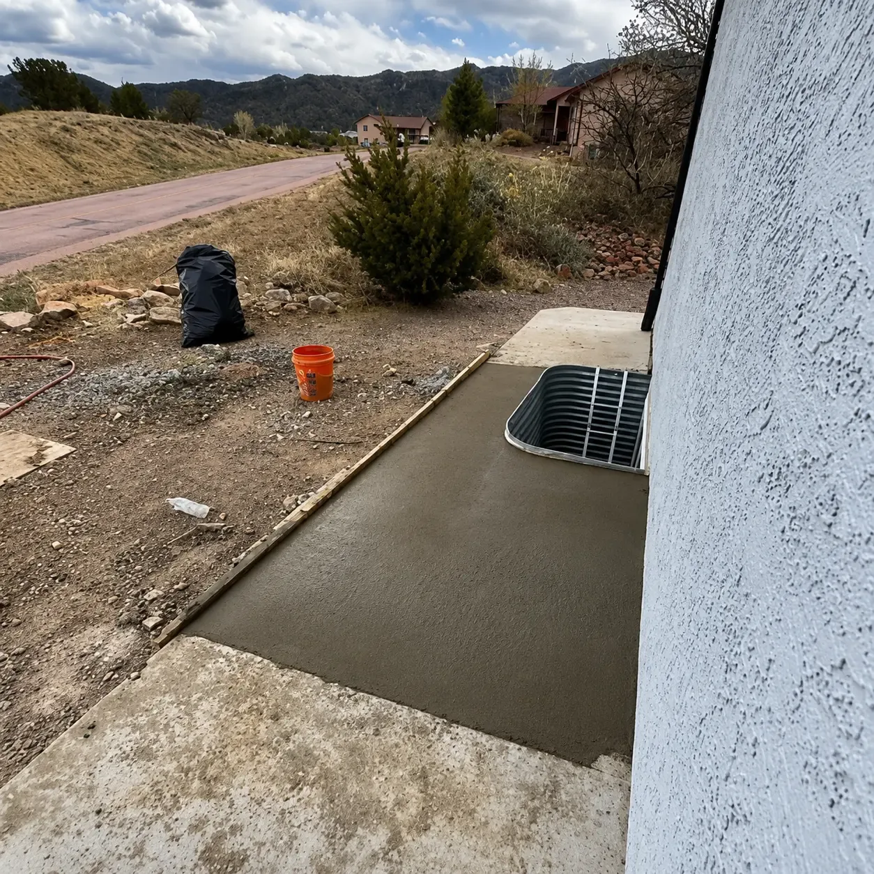 Fresh-poured concrete walkway and window well